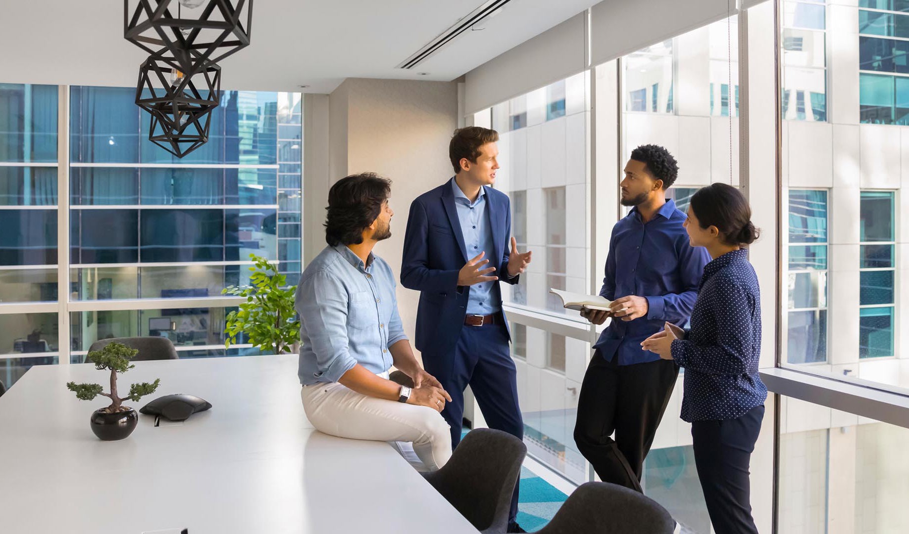 Four colleagues in a meeting room, having a discussion