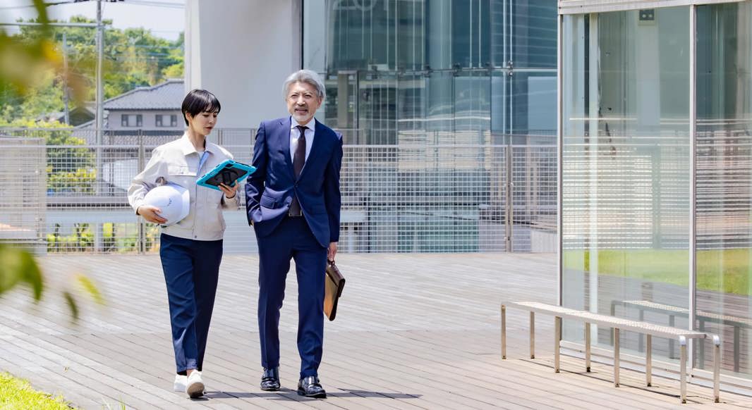 Two colleagues discussing information from a tablet