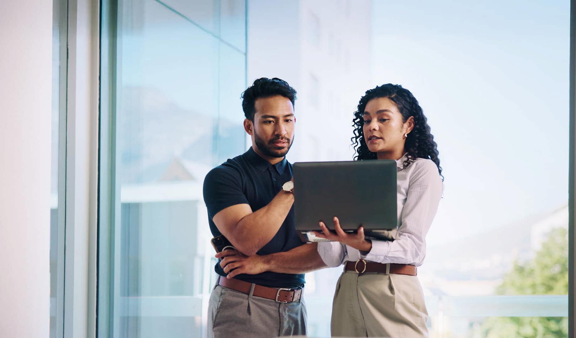 Two colleagues looking at a laptop