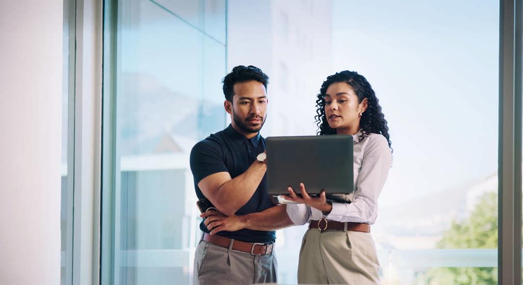 Two colleagues looking at a laptop