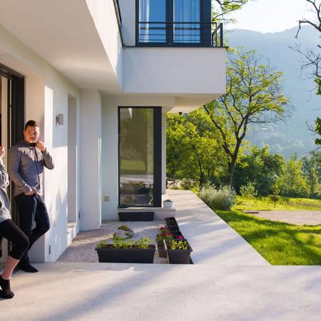 Two people standing at the doorway of a house