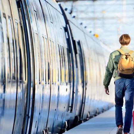 Passengers walking next to a train at a railway station