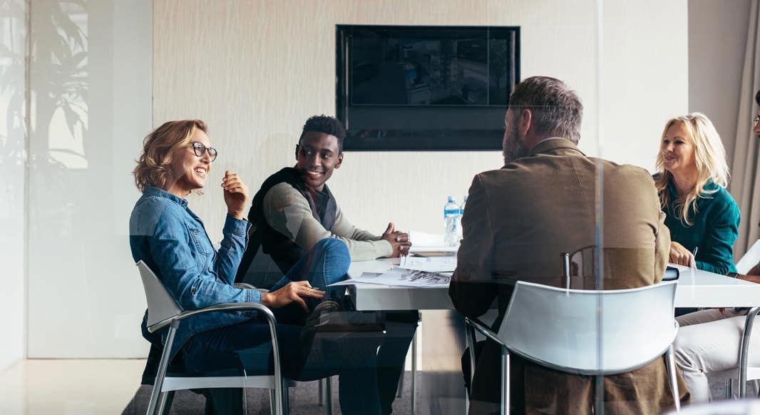 Five workers talking in a meeting